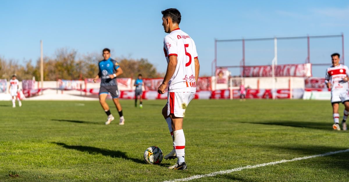 Soccer player in action during a daytime match on a sunny outdoor field.